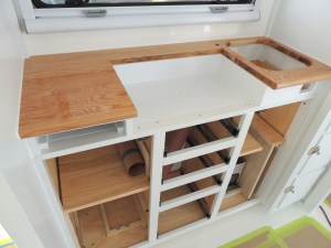 Kitchen lower cabinet installation sequence-heat shield for stove, stove, slide out cutting board, drawers, doors, sink