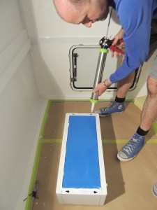 Prepped, bonded, and screwed overbed cabinets on rear bed walls