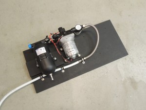 Painted plywood mounting palette for under sink pump assembly