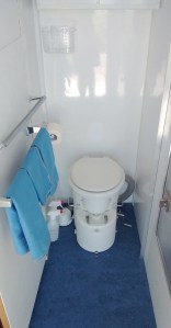 Installed bathroom door with mirror, waste basket, door handle, closing spring and towel bars